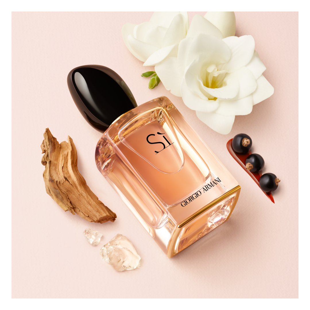 Giorgio Armani Sì Eau de Parfum: flacone con fiori bianchi, bacche scure e legno.