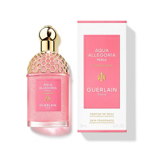 Pink Guerlain Aqua Allegoria Florabloom Perle bottle with a golden honeycomb pattern beside its white and pink original box on a white background.