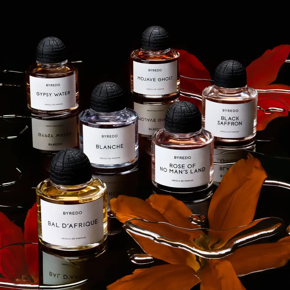 Byredo Duftphilosophie – Sammlung verschiedener Byredo Düfte auf schwarzem Hintergrund mit floralen Akzenten.