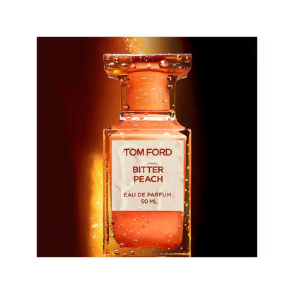 Tom Ford Bitter Peach Eau de Parfum mit Tropfen auf dem orangefarbenen Flakon vor dunklem Hintergrund.