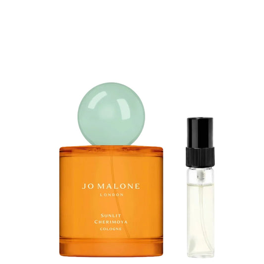 Parfumprobe von Jo Malone Sunlit Cherimoya Cologne im Sprühflakon neben dem orangefarbenen Originalflakon.