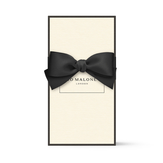 Cremefarbene Jo Malone London Geschenkbox mit schwarzer Schleife.