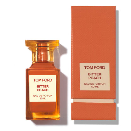 Tom Ford Bitter Peach Eau de Parfum im orangefarbenen Flakon neben der passenden Verpackung.