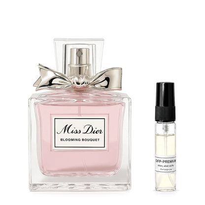 Dior Miss Dior Blooming Bouquet: Originalflakon neben einer DFP Parfumprobe im Glaszerstäuber mit schwarzer Kappe auf weissem Hintergrund.