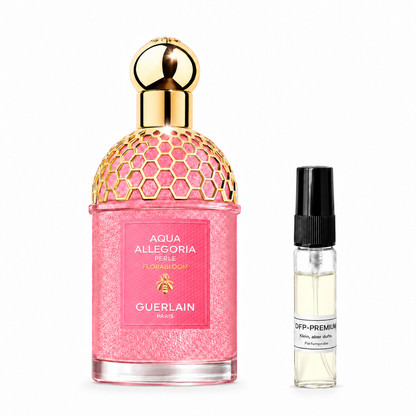 Pink Guerlain Aqua Allegoria Florabloom Perle bottle with a golden honeycomb pattern beside a DFP perfume sample on a white background.