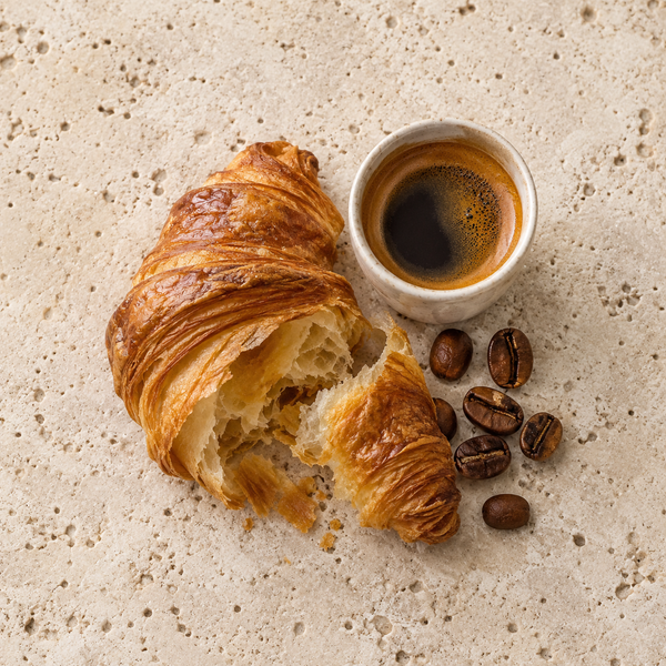 Blättriges Croissant und Kaffee als Symbol für den Kaffee-Croissant-Akkord