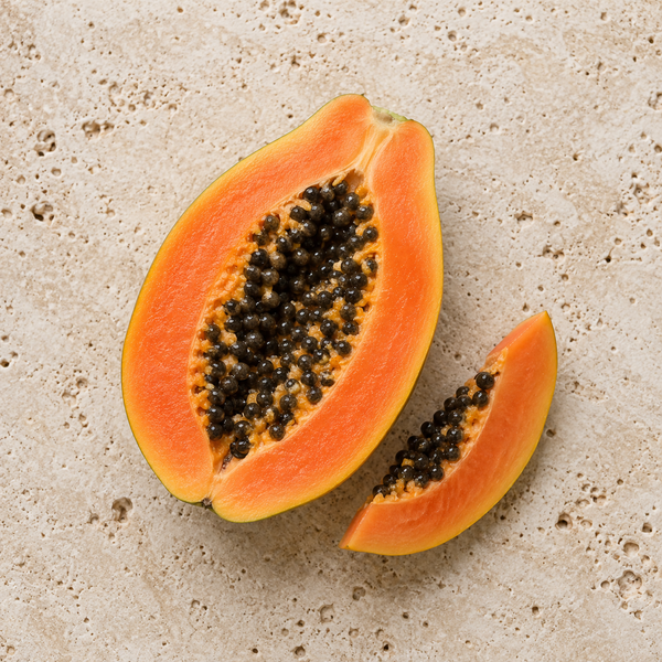 Aufgeschnittene Papaya mit orangefarbenem Fruchtfleisch und schwarzen Kernen
