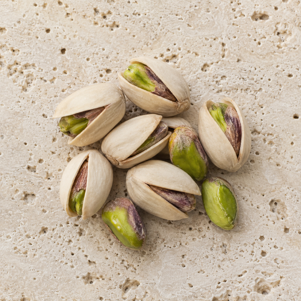 Pistaches en coques ouvertes et amandes vertes