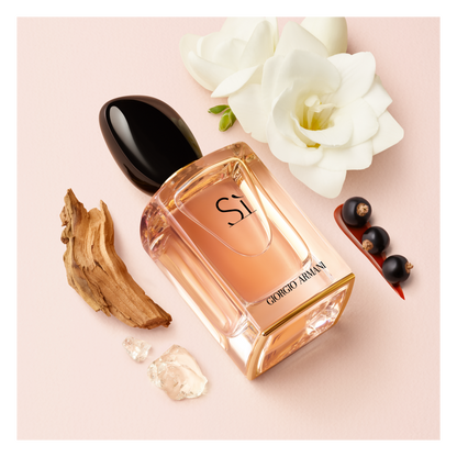 Giorgio Armani Sì Eau de Parfum: flacone con fiori bianchi, bacche scure e legno.