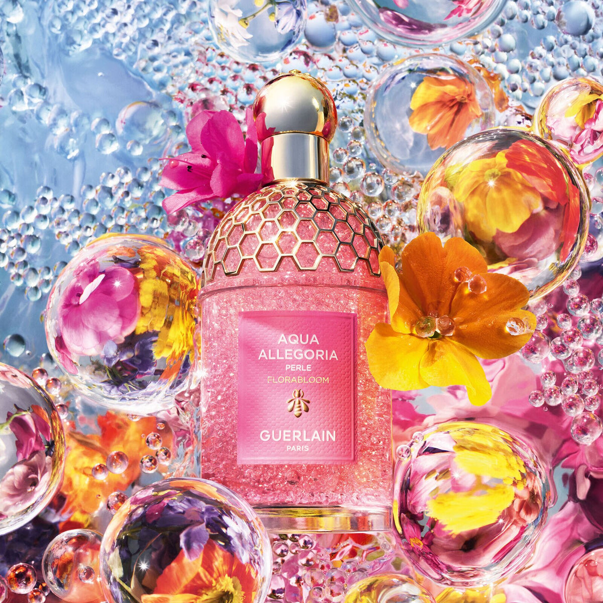 Guerlain Aqua Allegoria Florabloom Perle among pink and orange flowers and transparent pearls.