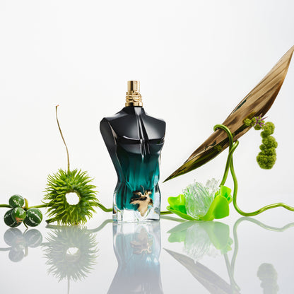 Jean Paul Gaultier Le Beau Le Parfum: flacone tra piante e foglie verdi.