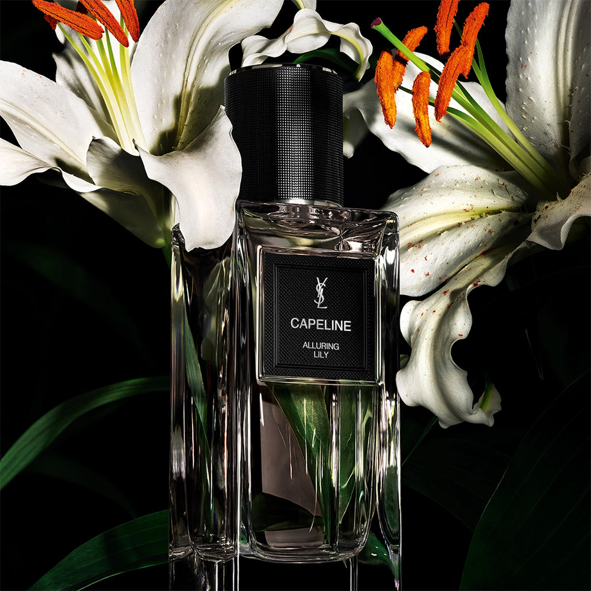 Yves Saint Laurent Capeline Alluring Lily Eau de Parfum bottle among white lilies and green leaves.